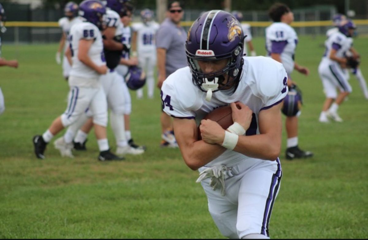 Sophomore Luke Harvey runs with the ball before a game